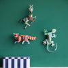 Three 3D paper animal wall decorations on a green wall with a striped box at the bottom.